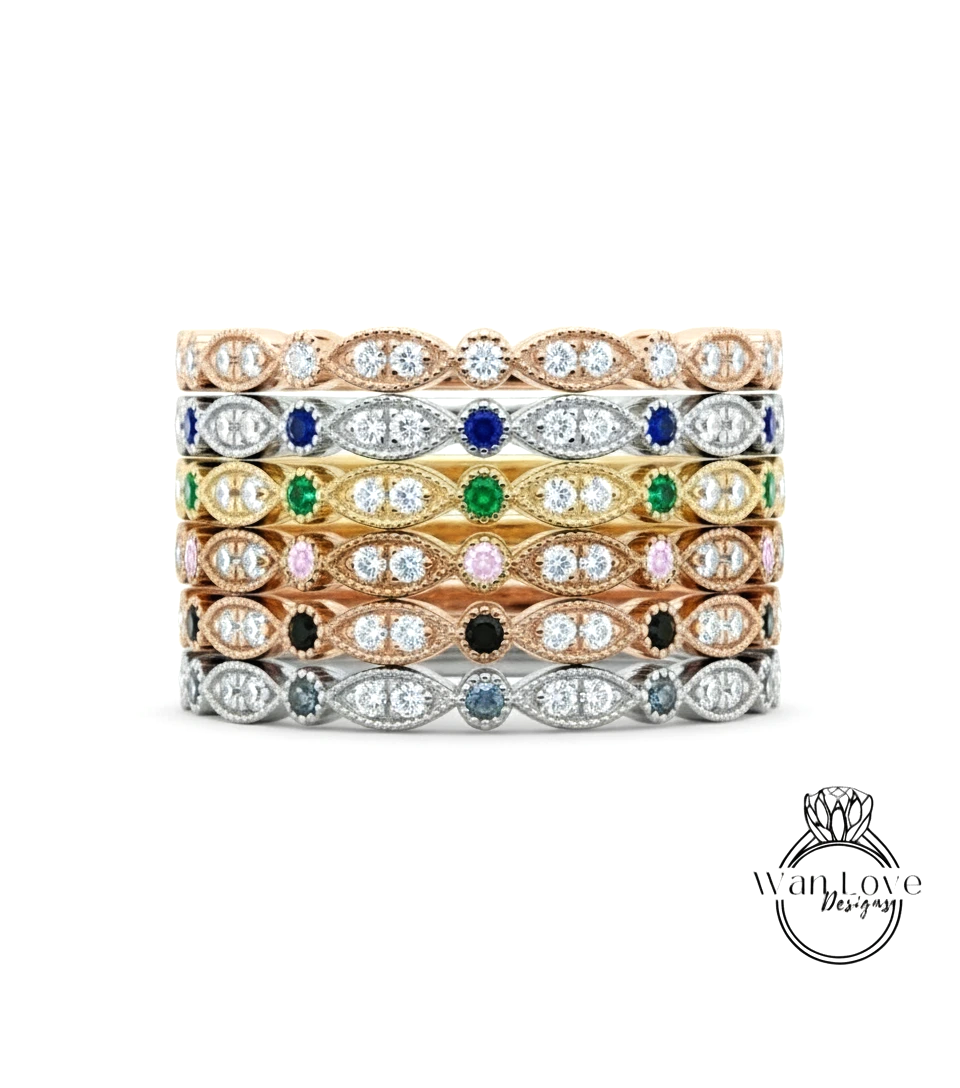 A stack of rings with various colored gemstones set in a decorative pattern.