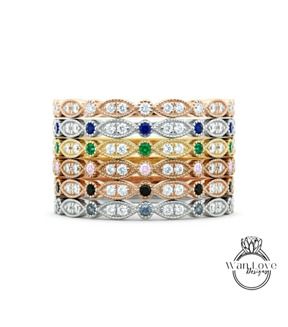 A stack of rings with various colored gemstones set in a decorative pattern.