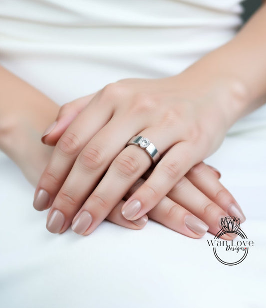 A close-up image of a person's hands wearing a silver ring.