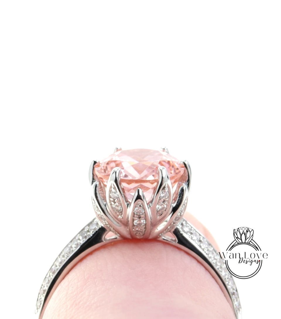 A close-up view of a beautiful pink gemstone ring with a large central gemstone surrounded by smaller gemstones set in a silver band.