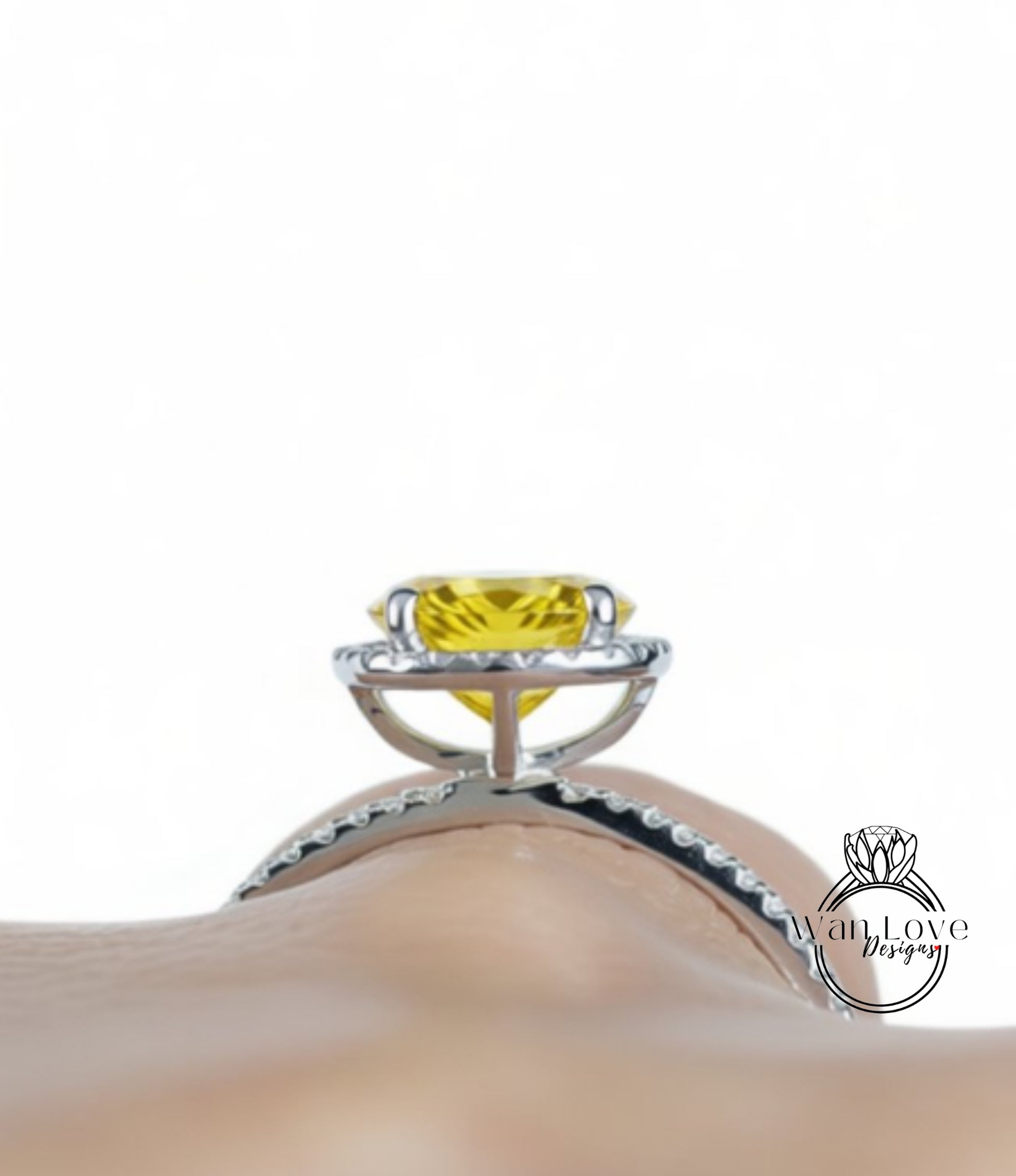 A close-up view of a yellow gemstone, possibly a diamond, set in a silver ring with a halo of smaller diamonds around it.