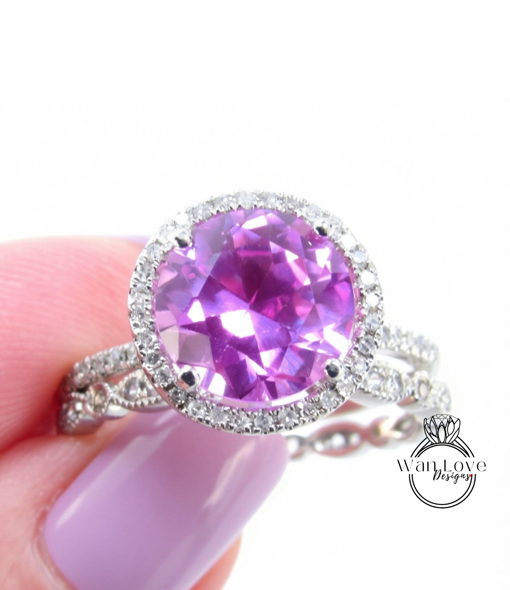 A close-up image of a person's hand holding a ring with a large, round purple gemstone surrounded by a halo of smaller diamonds.