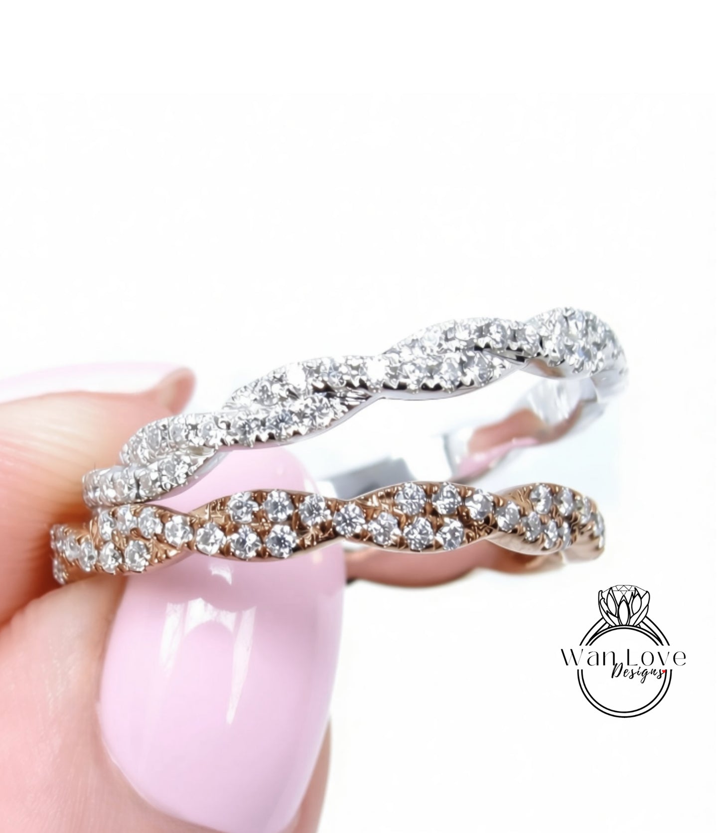 A close-up of a person's hand holding a ring with a pinkish-pink background.