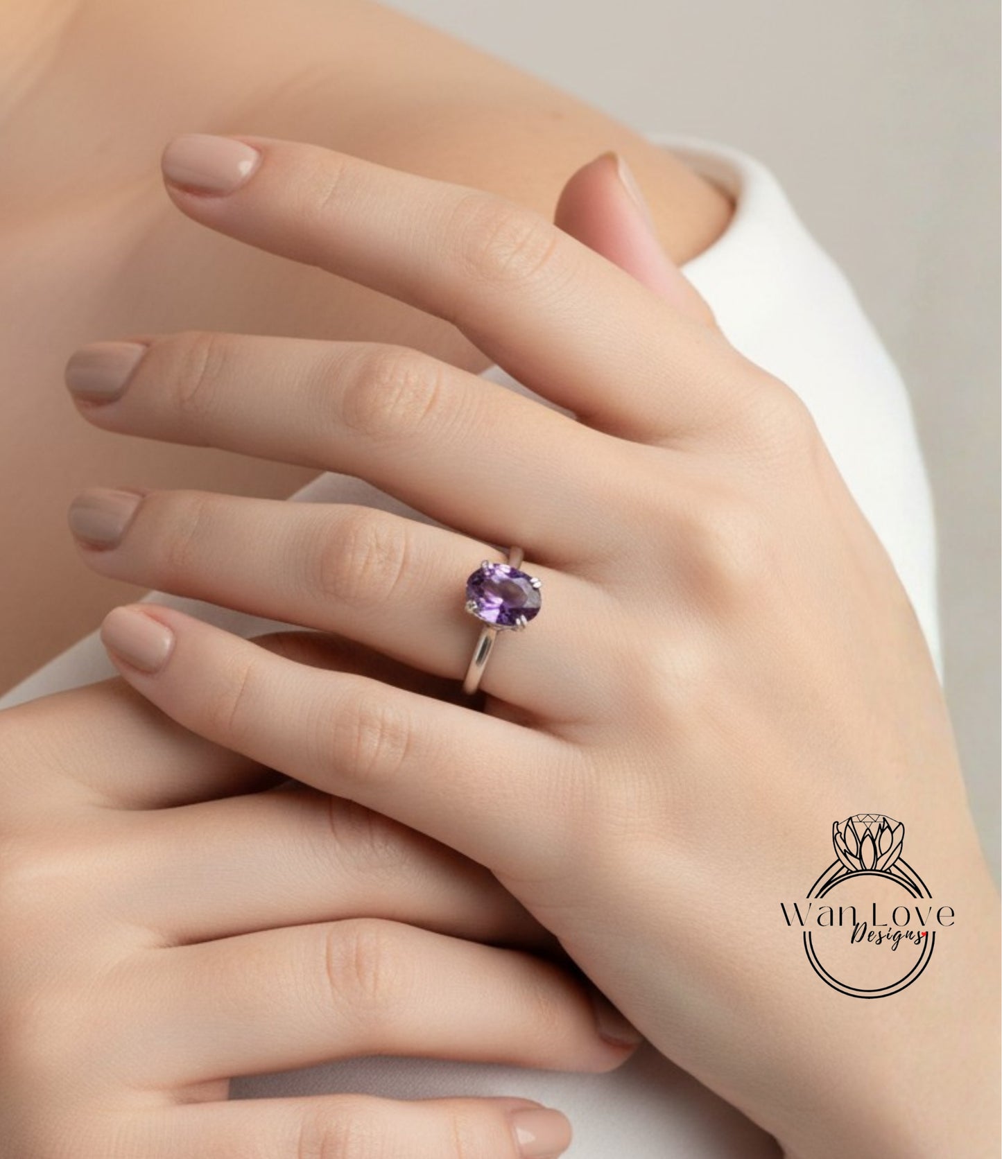 A close-up of a person's hand wearing a ring with a purple gemstone.