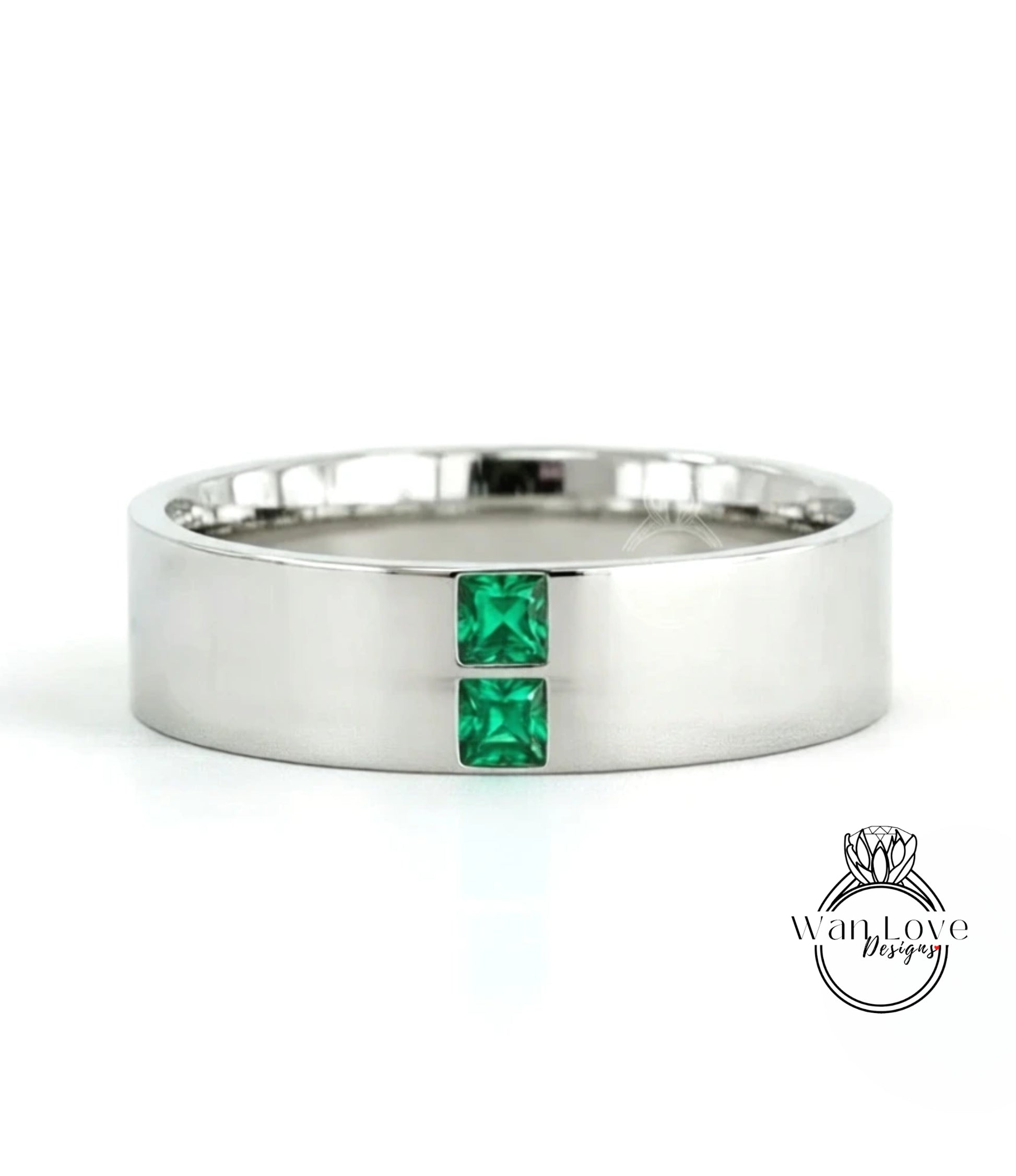 A silver-colored ring with two green gemstones set in the center.