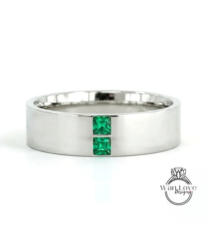 A silver-colored ring with two green gemstones set in the center.