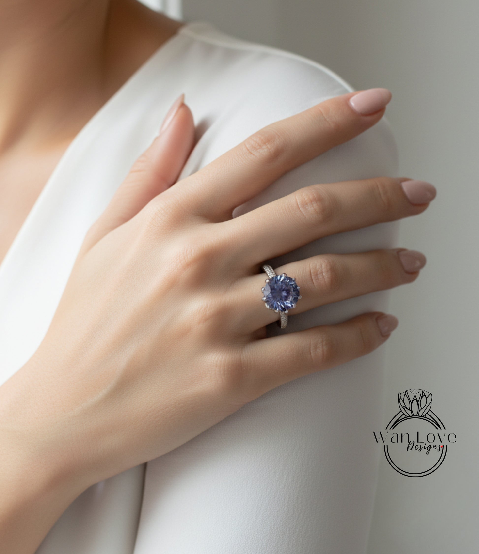 A close-up of a person's hand wearing a ring with a large, blue gemstone.