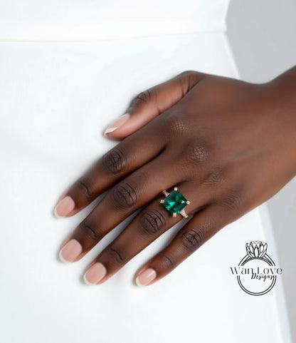 A close-up of a hand wearing a ring with a large green gemstone.