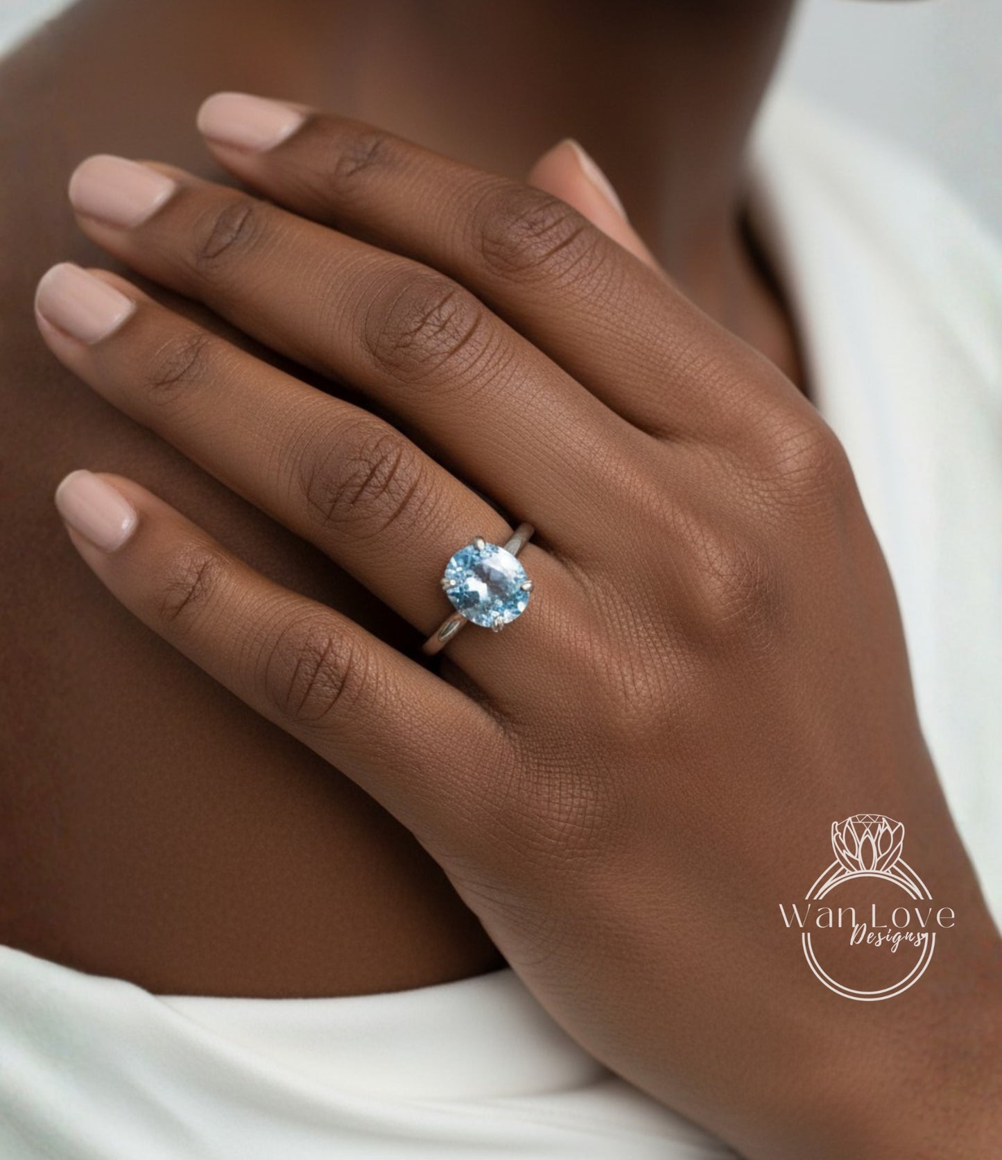 A close-up of a person's hand wearing a ring with a blue gemstone.