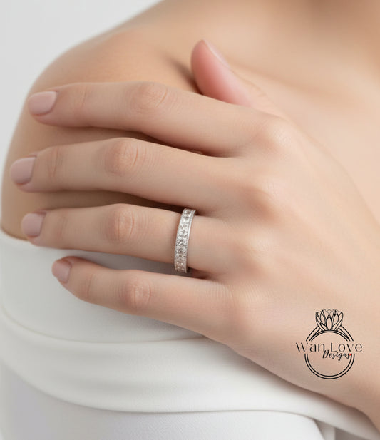 A close-up of a person's hand wearing a diamond ring on the ring finger.