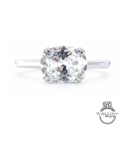 A close-up view of a diamond engagement ring with a large, clear gemstone set in a silver band.