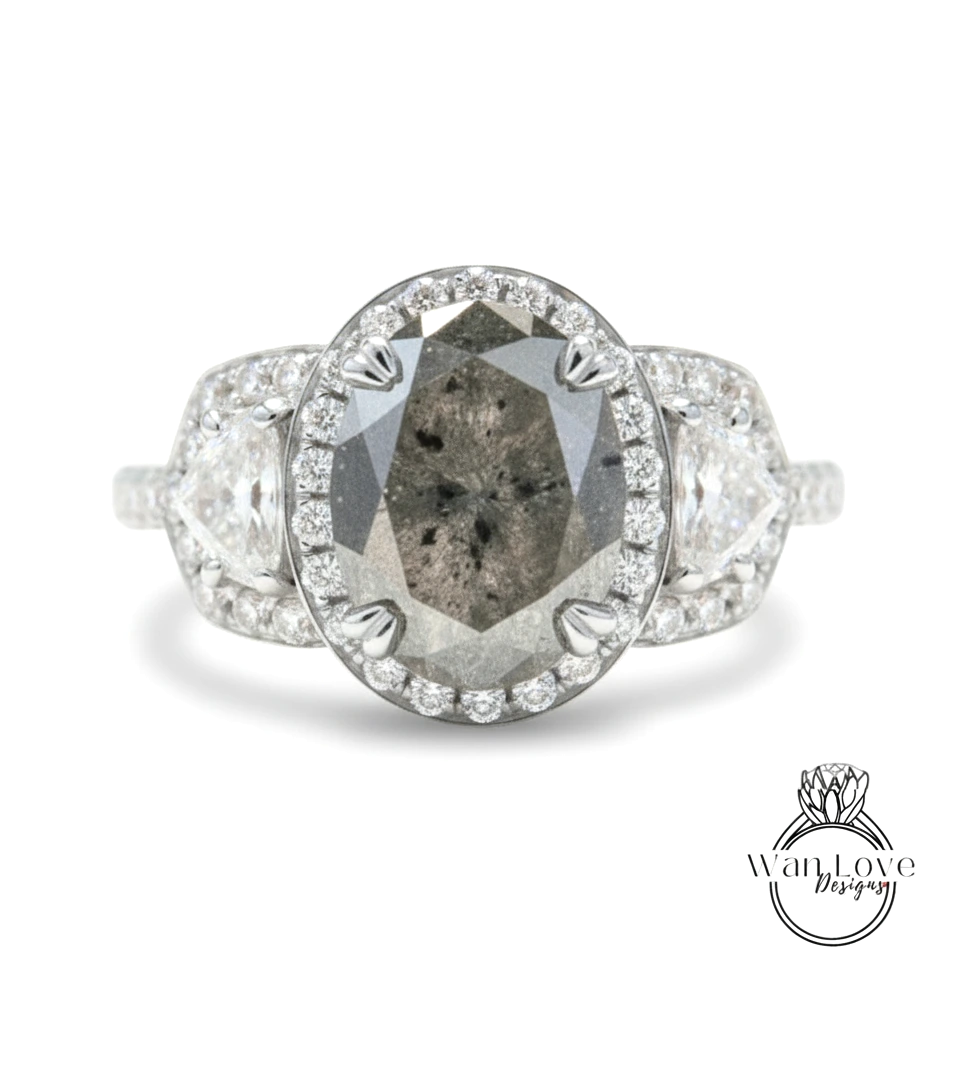 A diamond engagement ring with a large oval-shaped diamond at the center, surrounded by smaller diamonds and set in a halo of smaller diamonds.