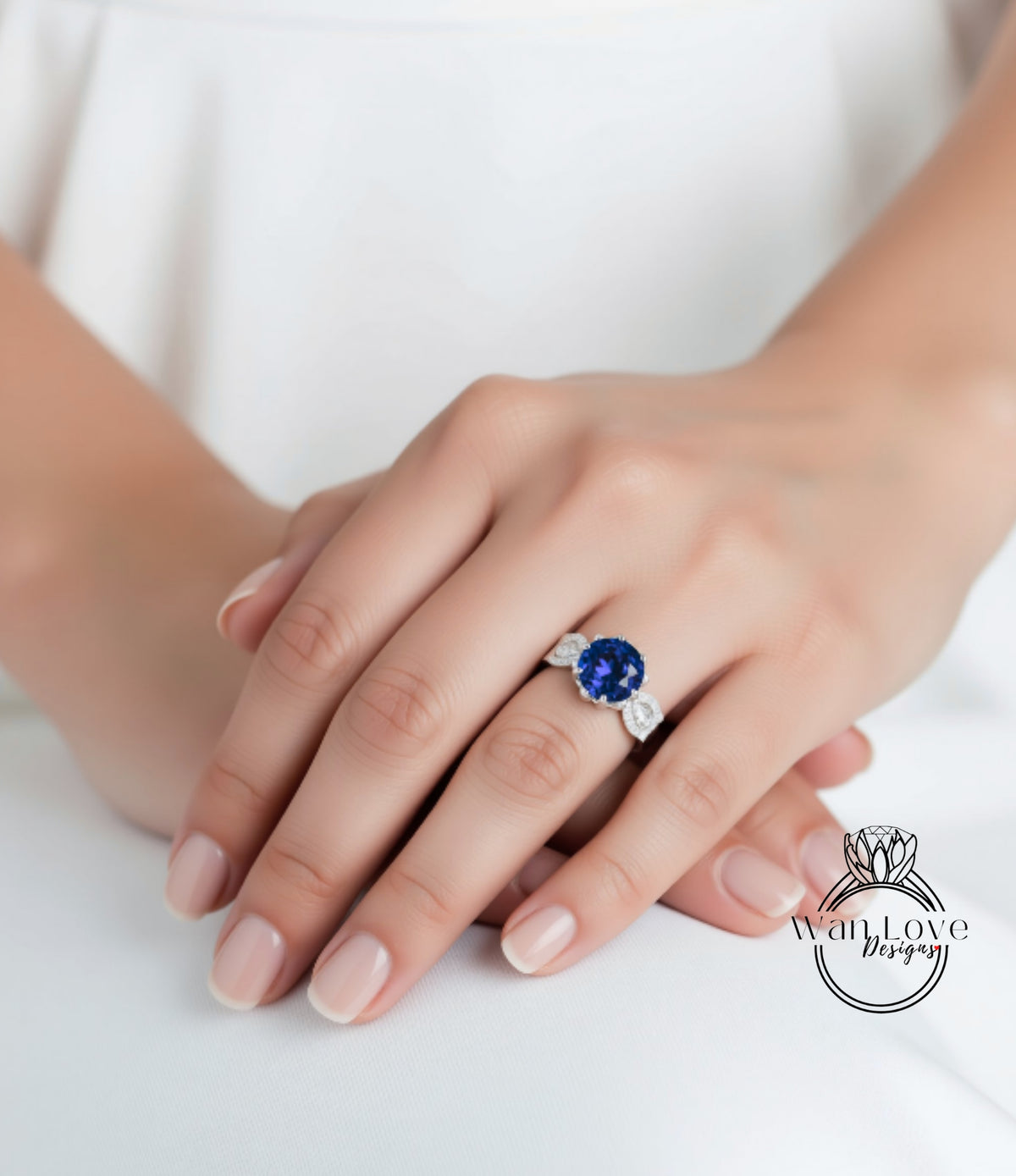 A close-up of a person's hand wearing a ring with a large blue gemstone.