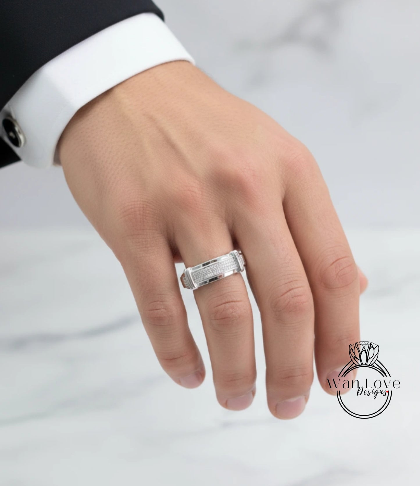 A close-up of a person's hand wearing a silver ring on the ring finger.