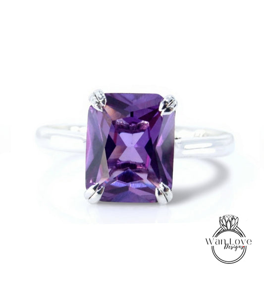 A ring with a large, purple gemstone, likely an amethyst, set in a silver band.