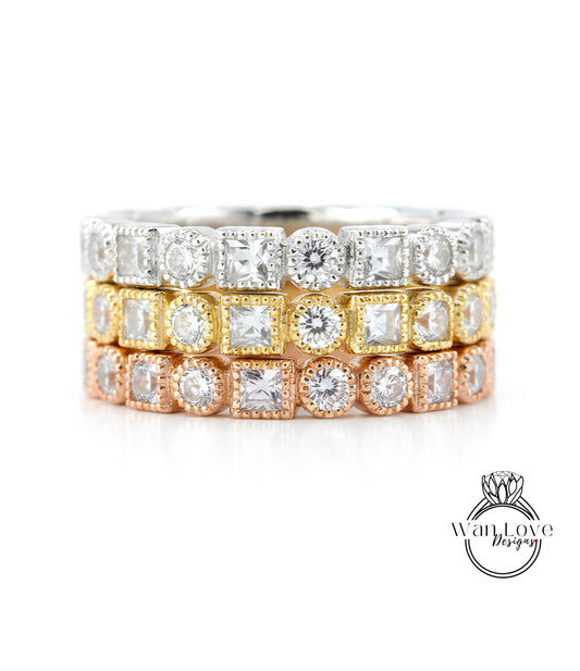 A stack of three rings with various gemstones, including diamonds, set in different colored metals.
