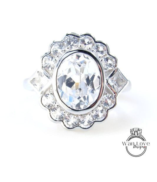 A close-up image of a diamond ring with a large oval-shaped gemstone surrounded by smaller diamonds.