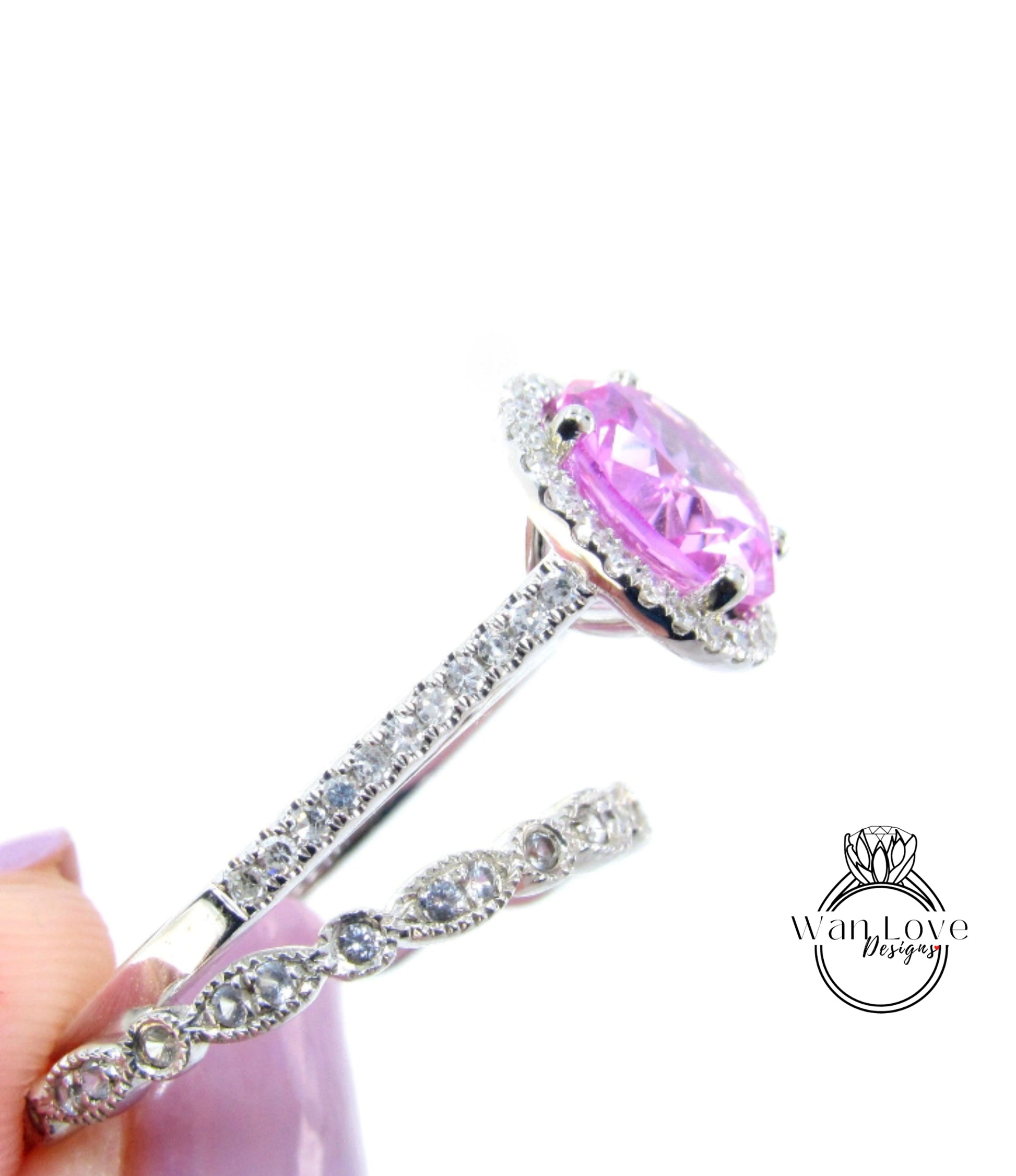 A close-up image of a diamond engagement ring with a large, round pink gemstone set in a halo of smaller diamonds.
