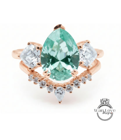 a beautiful ring with a large, green gemstone set in a rose gold band. The ring is adorned with smaller diamonds arranged in a decorative pattern around the band, creating an elegant and eye-catching design.