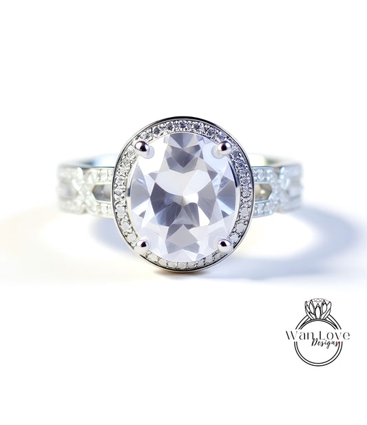A close-up of a silver ring with a large oval-shaped gemstone, surrounded by smaller diamonds.