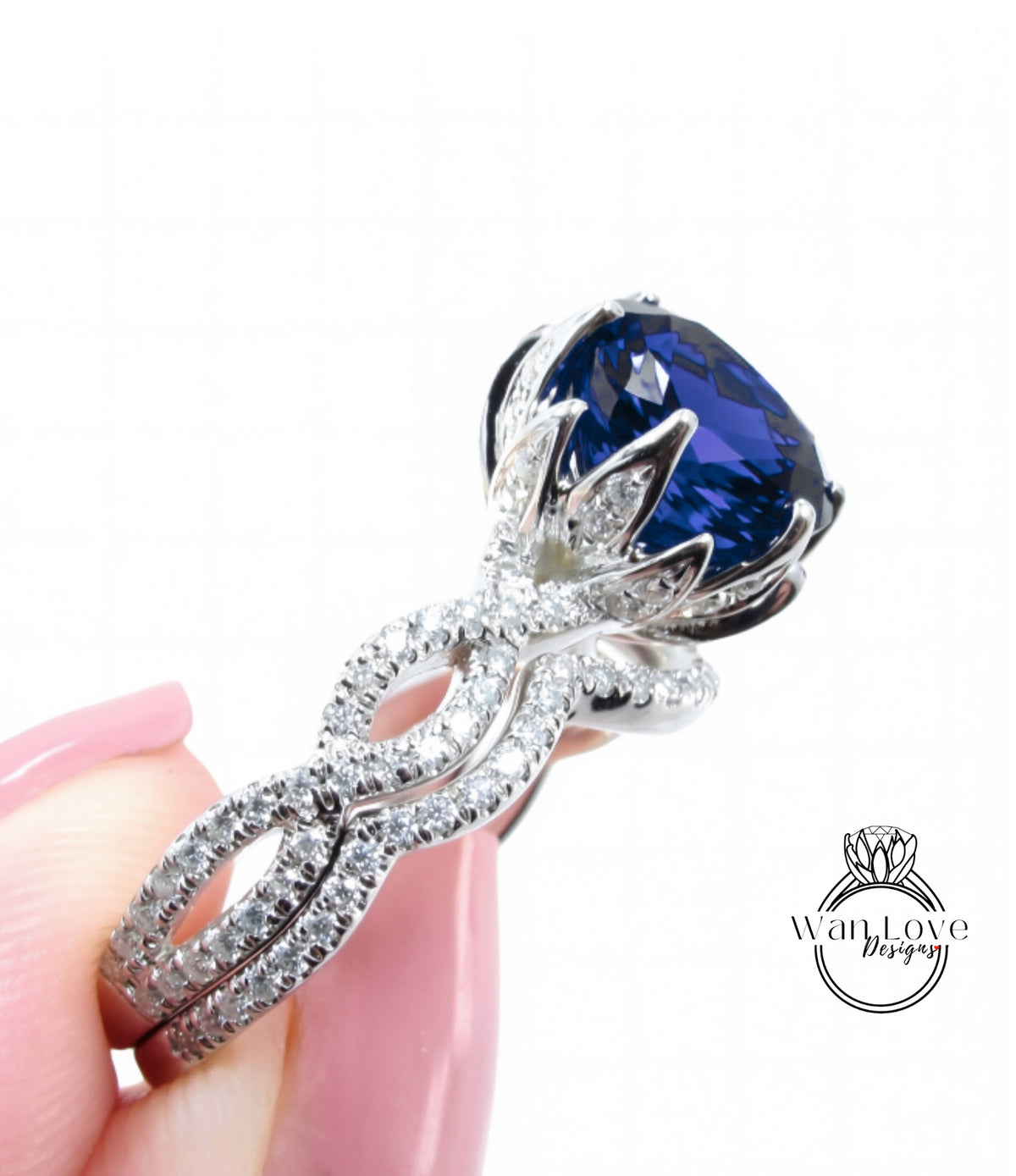 A close-up of a person's hand holding a diamond ring with a large blue gemstone.
