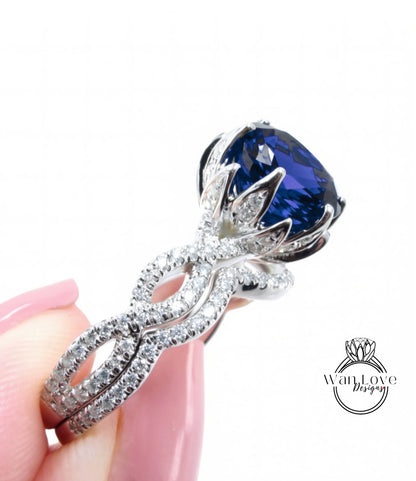 A close-up of a person's hand holding a diamond ring with a large blue gemstone.