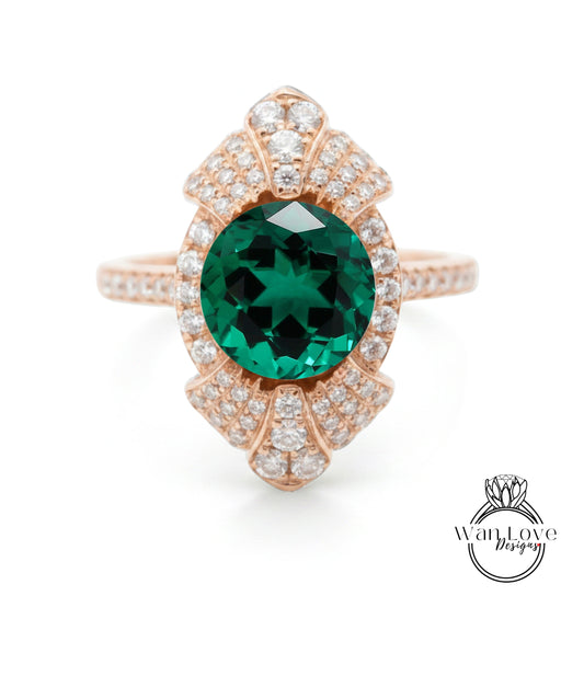 a beautiful ring with a large, green gemstone at the center, surrounded by a decorative pattern of smaller diamonds.