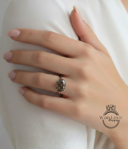 A close-up of a person's hand wearing a ring with a large, dark stone.