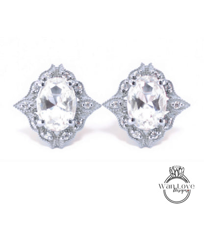 A pair of elegant earrings with large oval-shaped gemstones set in a decorative metal frame.