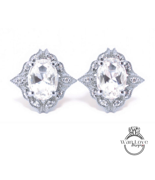 A pair of elegant earrings with large oval-shaped gemstones set in a decorative metal frame.