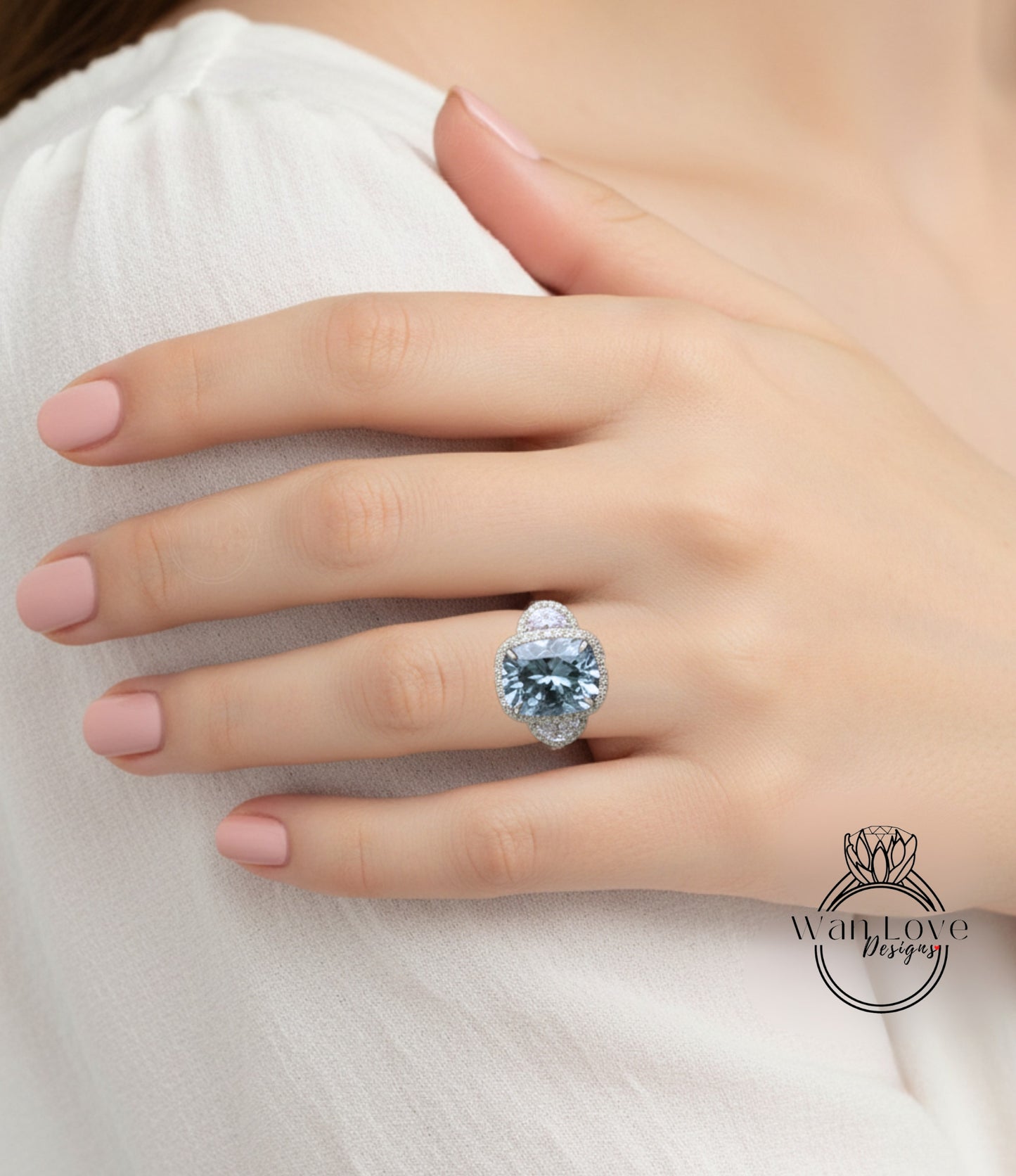 A close-up of a person's hand wearing a large, blue gemstone ring on the ring finger.