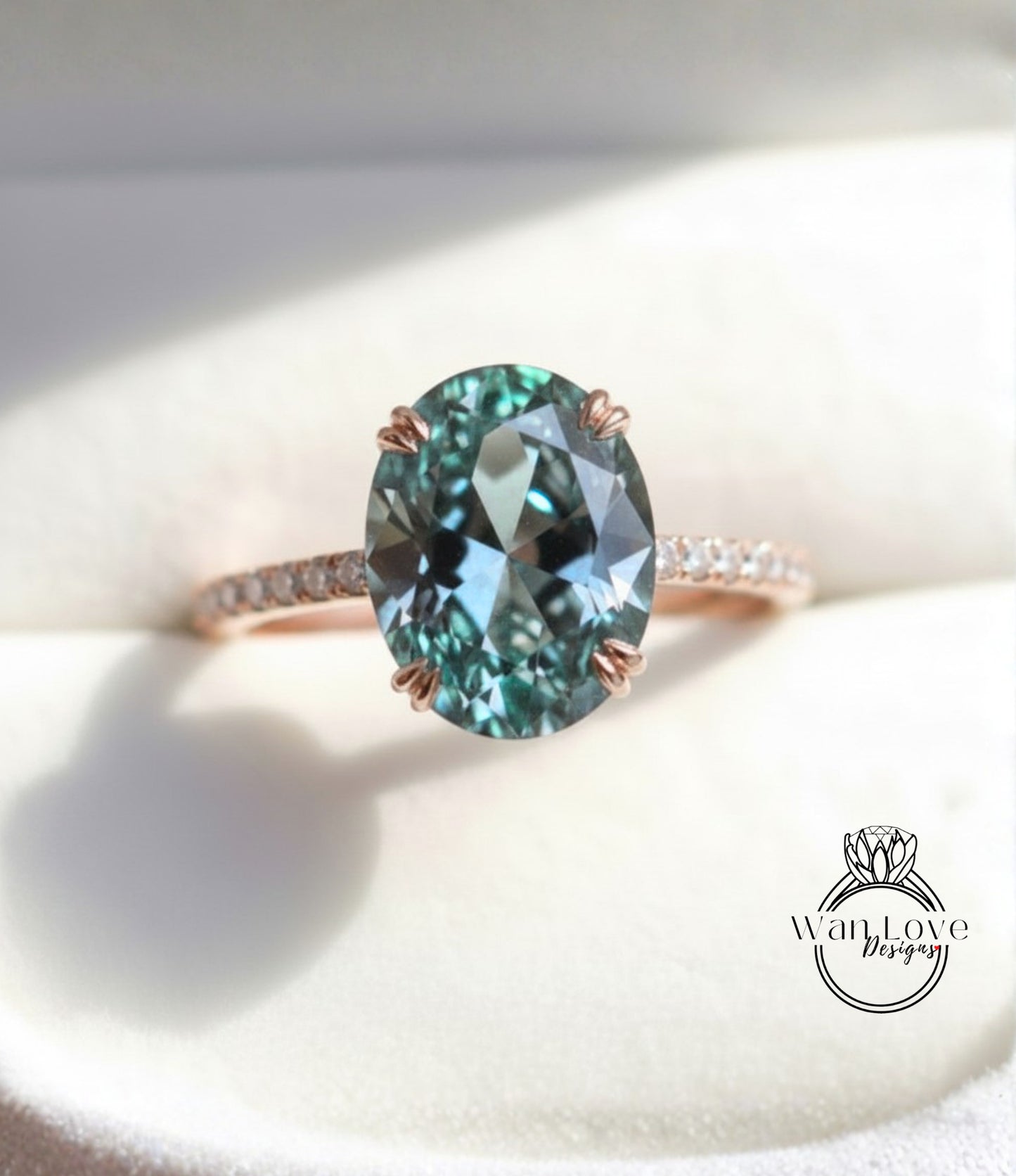 A close-up image of a rose gold ring with a large oval-shaped blue gemstone, possibly a sapphire or similar blue gemstone, set in a thin gold band.