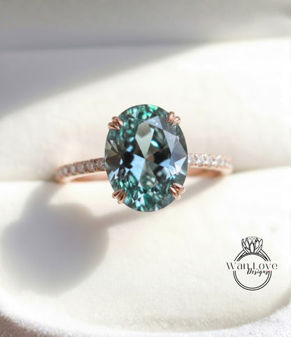 A close-up image of a rose gold ring with a large oval-shaped blue gemstone, possibly a sapphire or similar blue gemstone, set in a thin gold band.