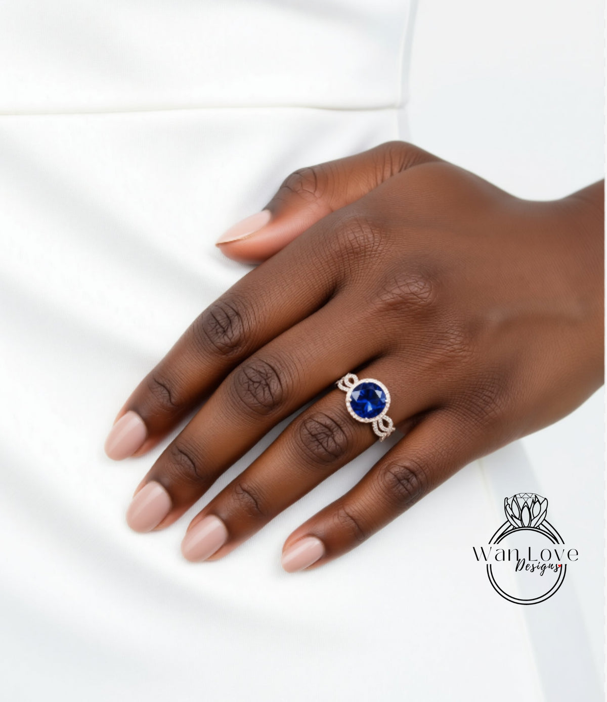 A close-up of a hand wearing a ring with a large blue gemstone.