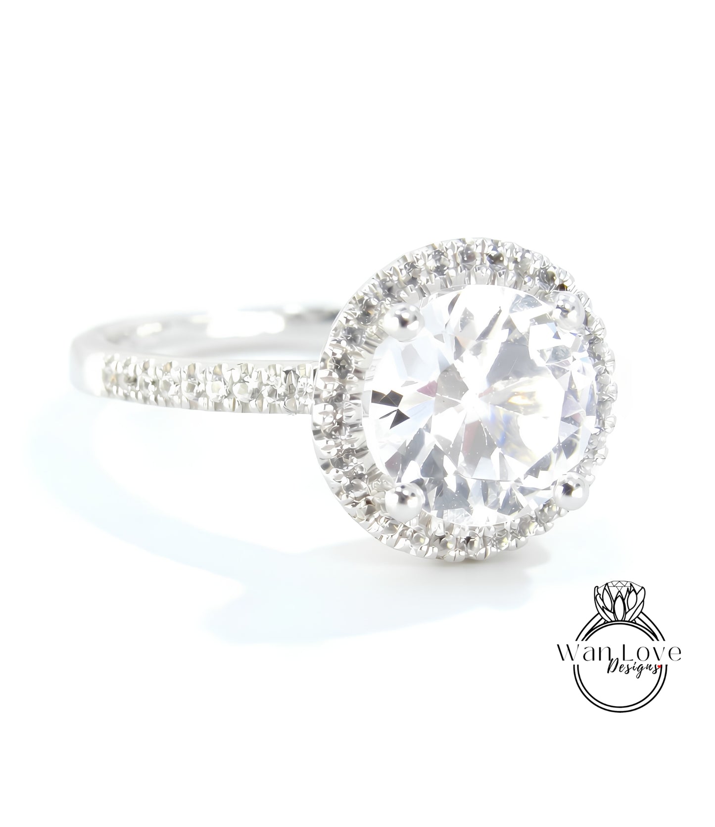 A close-up view of a diamond engagement ring with a large, round brilliant cut diamond set in a halo of smaller diamonds.