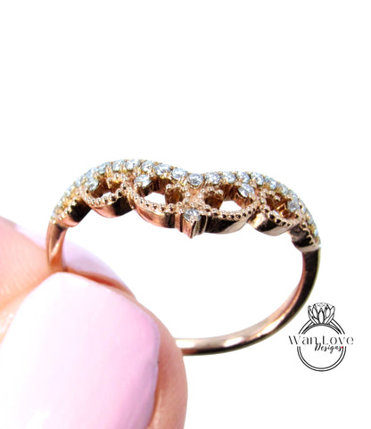 A close-up of a gold ring with a diamond-encrusted band, held in someone's hand against a white background.