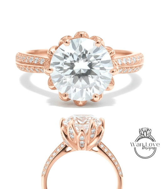 a beautiful rose gold engagement ring with a large, round diamond set in the center. The ring has a scalloped band and is adorned with small diamonds around the band.