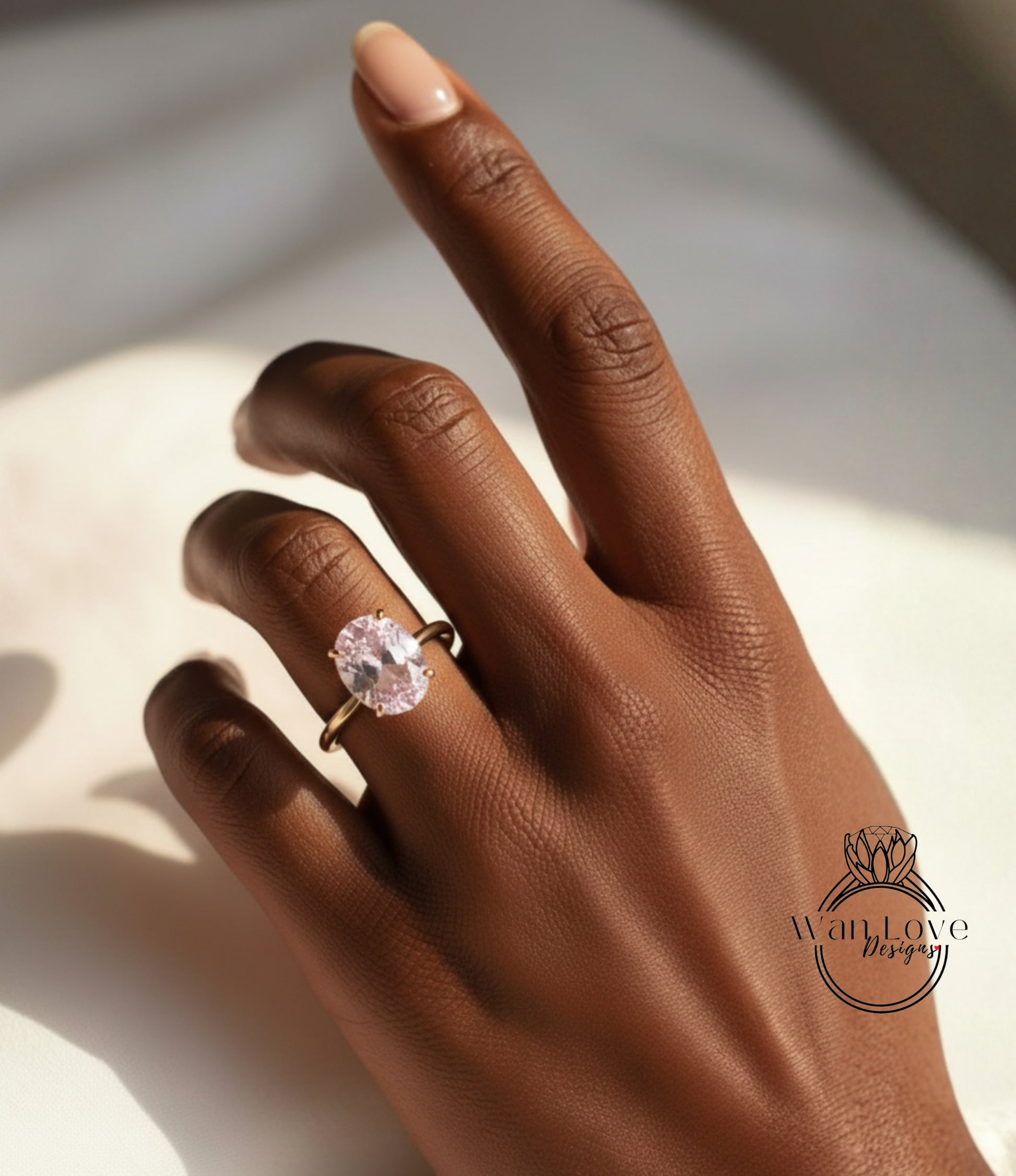 A close-up of a hand wearing a gold ring with a large oval-shaped gemstone.