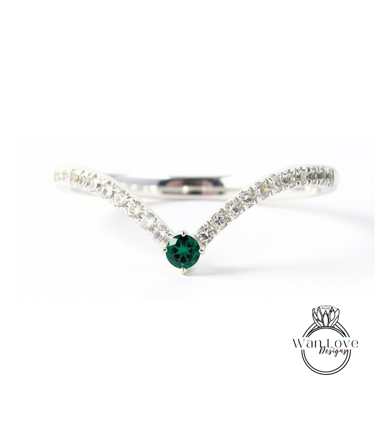 A silver ring with a large green gemstone in the center, set in a diamond-encrusted band.