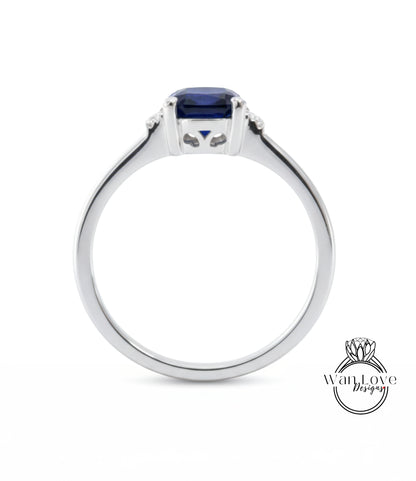 A silver ring with a blue gemstone, possibly a sapphire, set in the center.