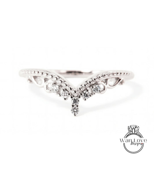 A silver ring with a decorative design featuring a central diamond and smaller diamonds surrounding it.