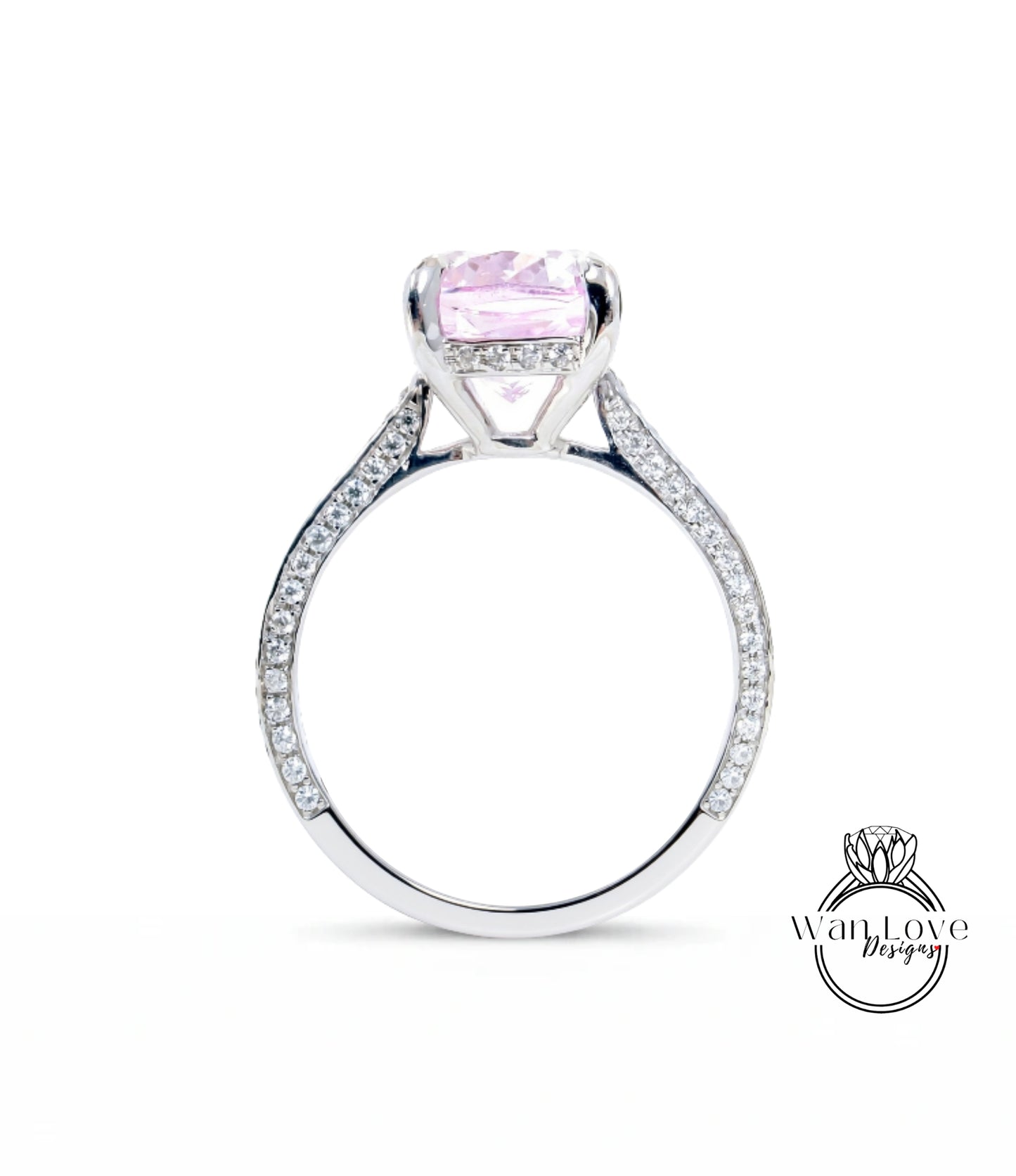 A silver engagement ring with a large pink gemstone, set in a diamond-encrusted band.