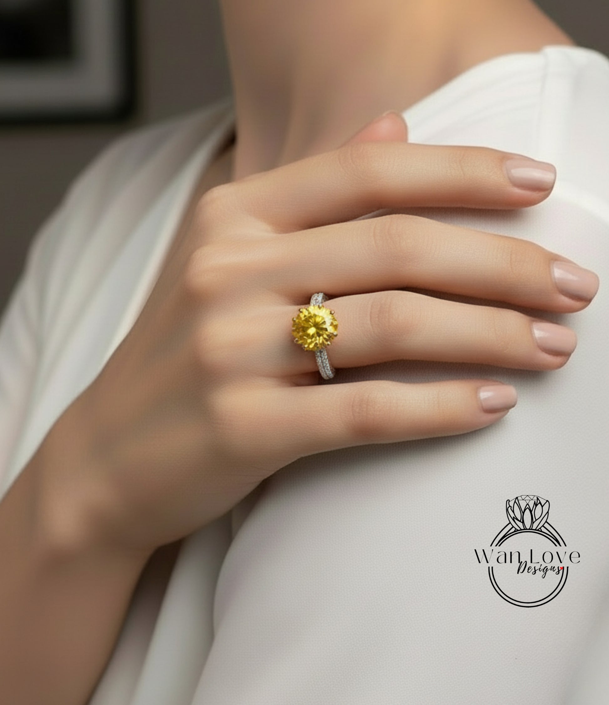 A close-up of a person's hand wearing a yellow diamond ring on the ring finger.