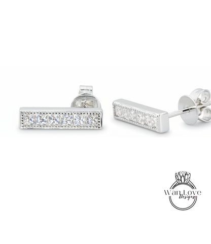 A pair of silver earrings with a row of small diamonds along the length of the bar.