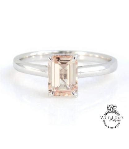 A silver engagement ring with a large, rectangular-shaped gemstone set in the center.