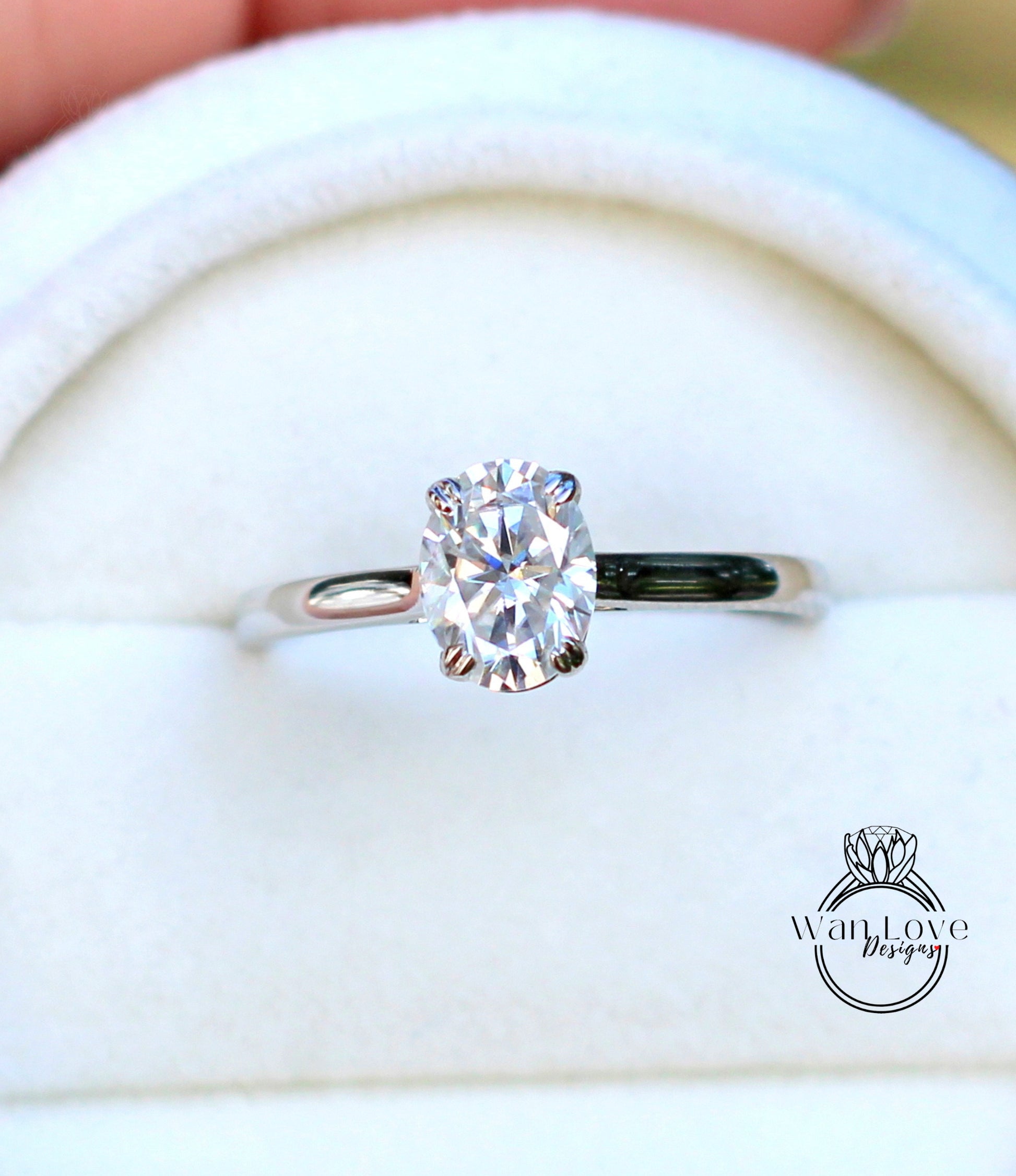 A close-up view of a diamond engagement ring, showcasing the oval-shaped diamond set in a silver band.