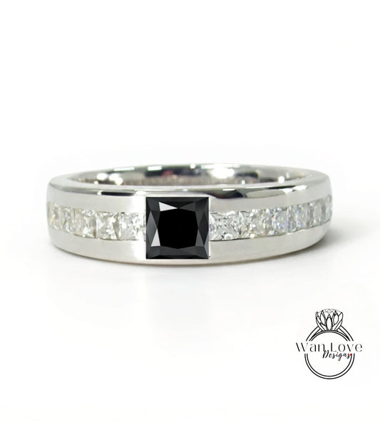 A silver ring with a large black diamond in the center, surrounded by smaller diamonds.