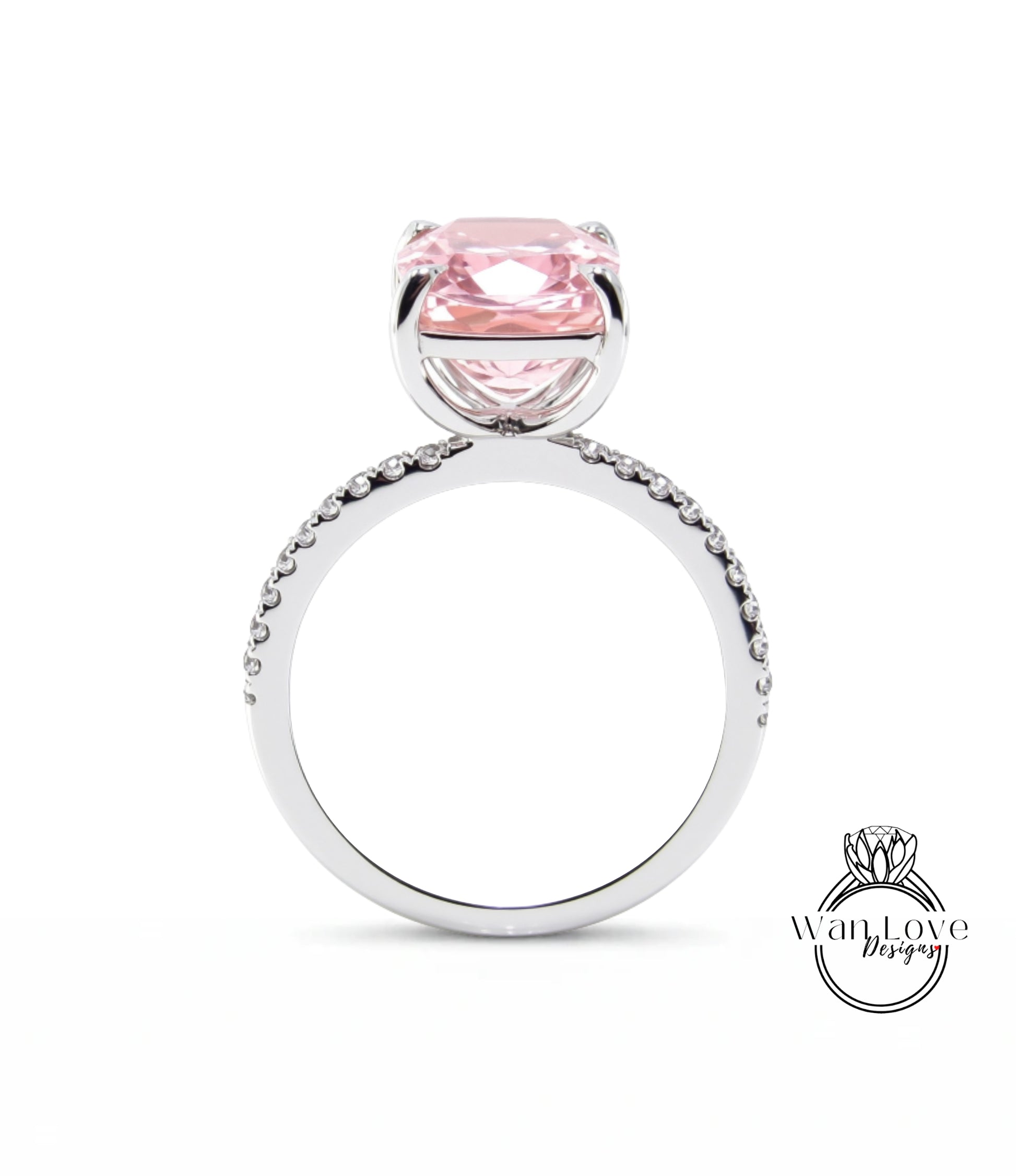 A silver ring with a large pink gemstone, likely a diamond, set in the center.