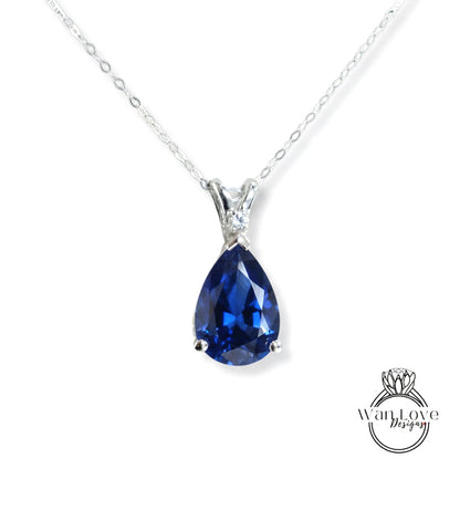 A silver necklace with a large blue gemstone pendant.