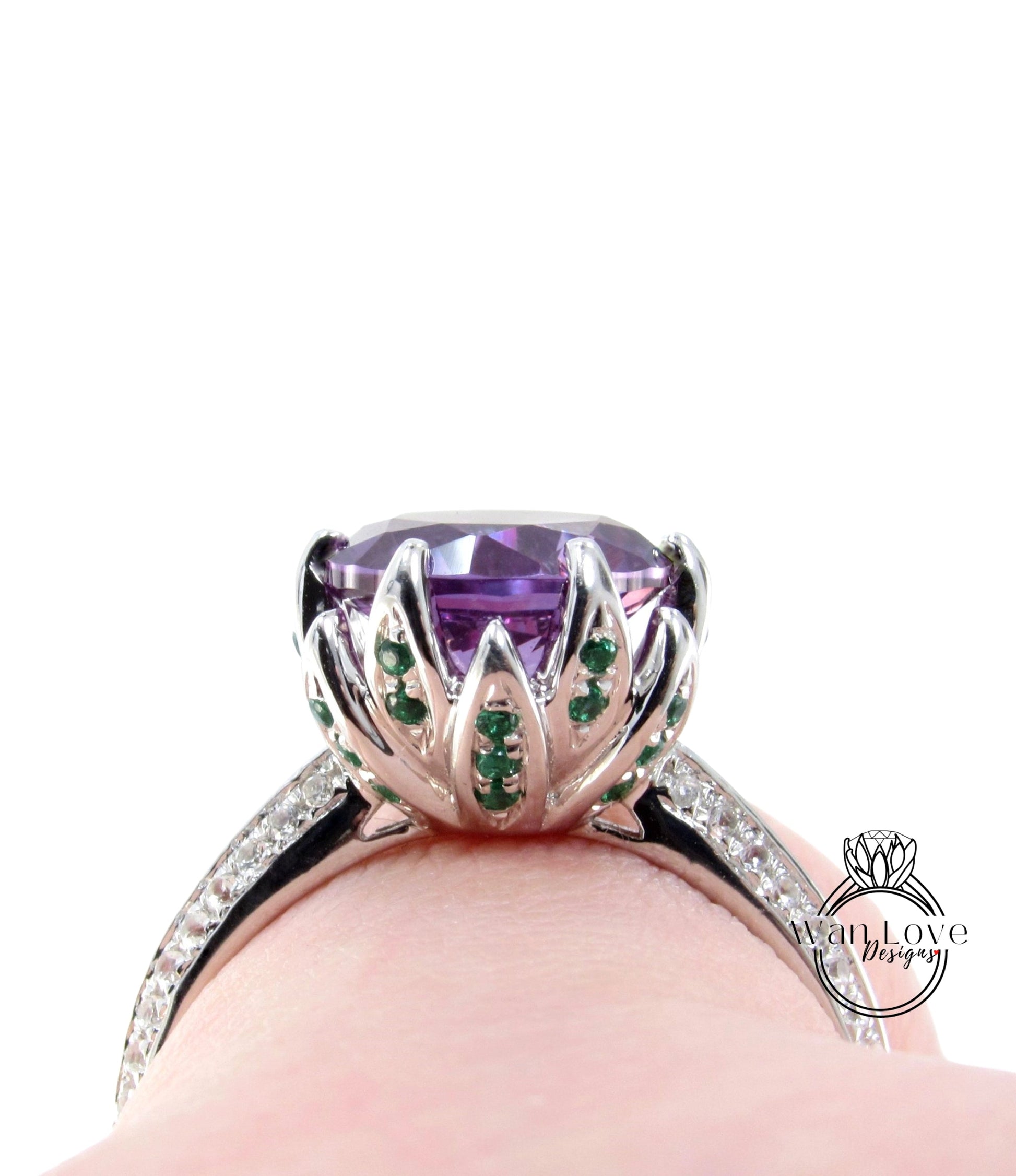 A close-up view of a silver ring with a large purple gemstone, surrounded by smaller green gemstones.